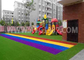 Kinder, die farbiges Sport-künstliches Gras mit Schock-Auflagen-Wiese setzend spielen fournisseur